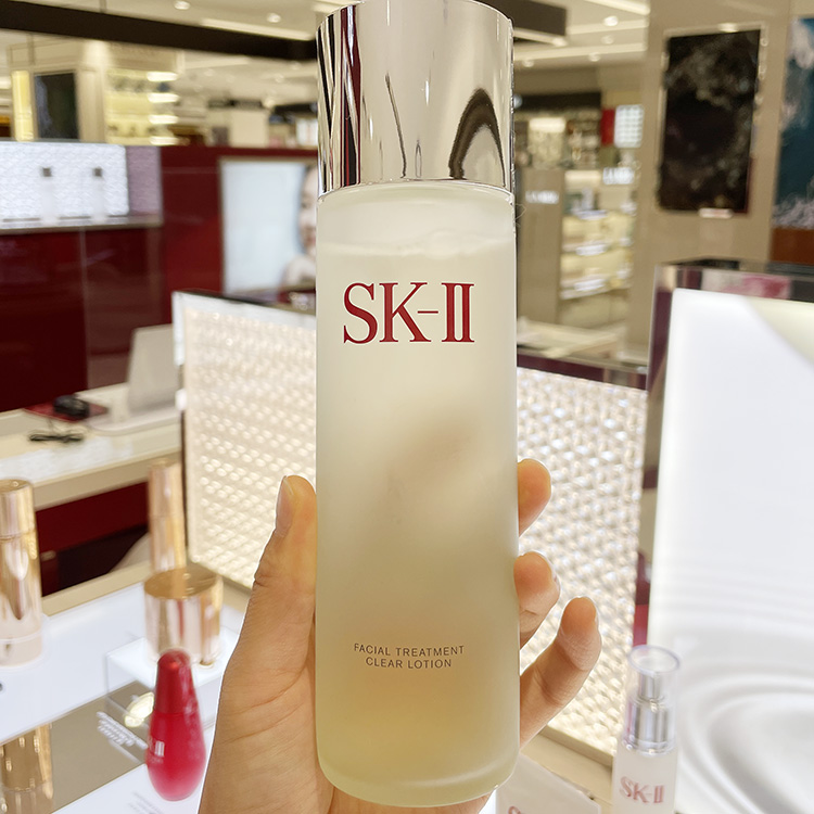 SK-II神仙水产品特写，展示其标志性的瓶身和淡金色液体